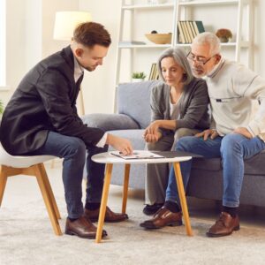 Couple sitting with a financial adviser and looking at paperwork